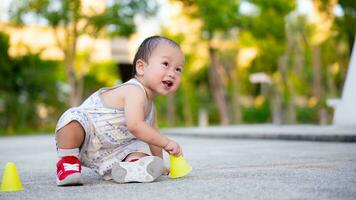 Active toddler boy 1 year old trying to get up. Son having fun outdoors at sunny spring or autumn day. Funny smiling baby crawling. Small child lies on floor and tries to get up. Kid learning to walk. photo