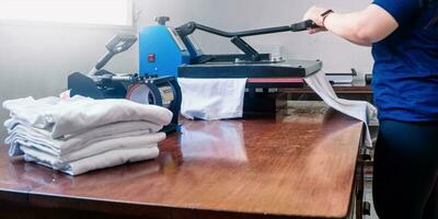 manipulating a sublimation machine ironing a shirt. photo