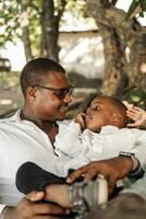 Young adult black man holding a baby son in her arms. photo