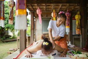 Massage and spa relaxing treatment of office syndrome traditional thai massage style. Asain female masseuse doing massage and skin scrub treat back pain, arm pain and stress for good skin and health. photo