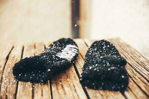 Black warm winter knitted mittens with snowflakes. Selective focus. photo