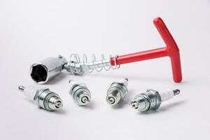 Car spark plugs and key on white background. Car spare parts. photo