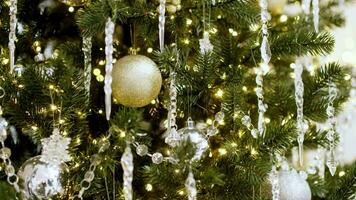 Kerstmis boom versierd met gouden en zilver ballen. sparkly glas speelgoed en schijnend lichten Aan prachtig versierd Kerstmis boom Aan nieuw jaar vooravond in knus huis met atmosfeer van magie in lucht video