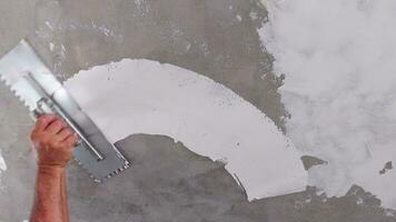 Worker puts finishing layer of stucco on the wall using a plastering trowel video