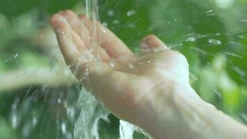 langzaam beweging van Doorzichtig water streaming Aan een menselijk hand- nemen zorg video