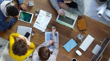 Top view of four business people sitting at modern office desk video