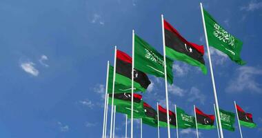 Libia y ksa, Reino de saudi arabia banderas ondulación juntos en el cielo, sin costura lazo en viento, espacio en izquierda lado para diseño o información, 3d representación video