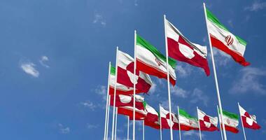 Greenland and Iran Flags Waving Together in the Sky, Seamless Loop in Wind, Space on Left Side for Design or Information, 3D Rendering video