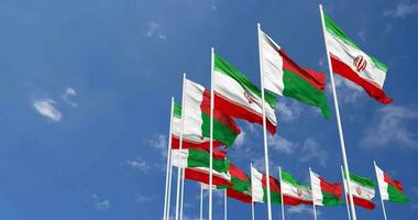 Madagascar and Iran Flags Waving Together in the Sky, Seamless Loop in Wind, Space on Left Side for Design or Information, 3D Rendering video