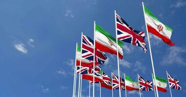 United Kingdom and Iran Flags Waving Together in the Sky, Seamless Loop in Wind, Space on Left Side for Design or Information, 3D Rendering video