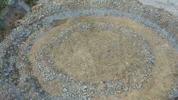 an aerial view of a circular pit with rocks video