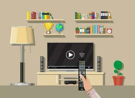 Modern living room interior. Tv on stand. Library wooden book shelf. Globe, lamp, clocks, cactus, cup. Bookcase with different books. Hand with remote control. Vector illustration in flat style