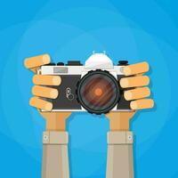 Hands holding photo camera. vector illustration in flat style on blue background