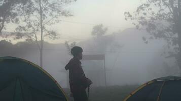 Gorontalo, Indonesia - December 10, 2023 - A climber surrounded by fog on Arang Hill in the morning photo