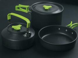 cookware set, antique dinner set isolated on black background, black metal cookware set photo