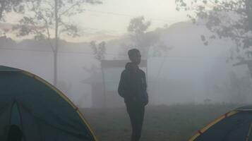 Gorontalo, Indonesia - December 10, 2023 - A climber surrounded by fog on Arang Hill in the morning photo