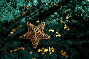 Abstract Christmas background with gold stars on a green velvet background. photo