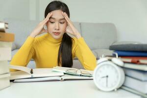 Asian student woman have anxiety because of exams, female prepare for test and learning lessons in the library. stress, despair, haste, misunderstanding reading, discouraged, expectation, knowledge photo