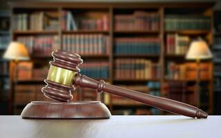 Gavel Resting on a Table Inside a Law Office with Bookshelf of Law Books in the Background. photo