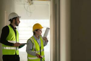 Engineer and architect working on the construction site, double-checking plans and process. photo