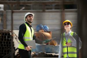 Engineer and architect working on the construction site, double-checking plans and process. photo