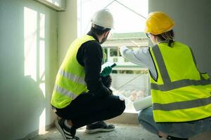 Engineer and architect working on the construction site, double-checking plans and process. photo