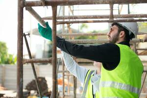 Engineer and architect working on the construction site, double-checking plans and process. photo