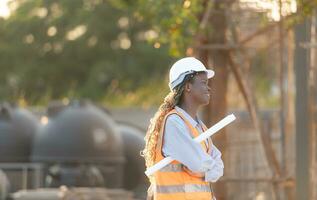 At the building site, a female engineer holds a blueprint in hand. photo