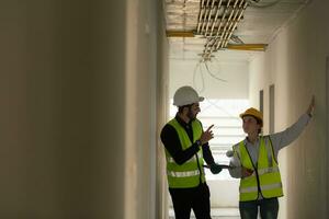 Engineer and architect working on the construction site, double-checking plans and process. photo