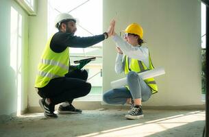 Engineer and architect working on the construction site, double-checking plans and process. photo