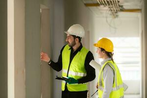 Engineer and architect working on the construction site, double-checking plans and process. photo