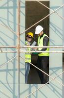 Engineer and architect working on the construction site, double-checking plans and process. photo