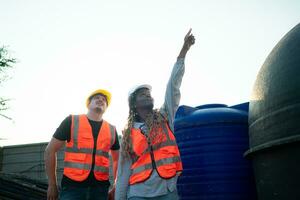 arquitecto y ingeniero con experiencia en de varios pisos edificio construcción, inspeccionando el agua sistema en un construcción edificio. foto