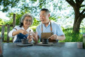 In the pottery workshop, an Asian retired couple is engaged in pottery making and clay painting activities. photo