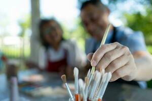 In the pottery workshop, an Asian retired couple is engaged in pottery making and clay painting activities. photo