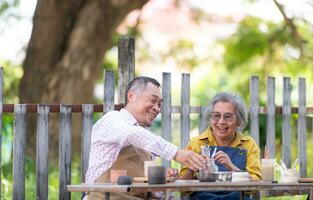 In the pottery workshop, an Asian retired couple is engaged in pottery making and clay painting activities. photo