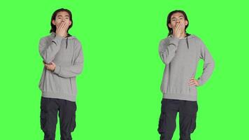 Male model feeling tired and yawning after not getting enough sleep, posing with fatigue over greenscreen template. Young asian person being extremely sleepy and exhausted, fall asleep. video