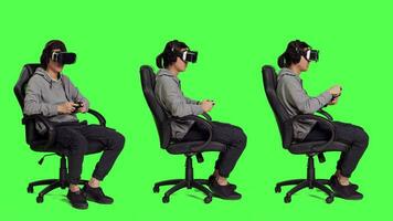 jong vent spelen telefoon spellen met veel gadgets over- vol lichaam groene scherm, concurrerende in online gaming wedstrijd met zijn vrienden. Aziatisch mannetje gamer gevoel blij met vr hoofdtelefoon. video