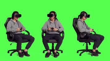 jogador tendo Diversão com vr óculos e controlador, jogando conectados multiplayer concurso com de outros jogadores. ásia homem desfrutando lazer atividade enquanto ele senta em cadeira contra cheio corpo tela verde. video