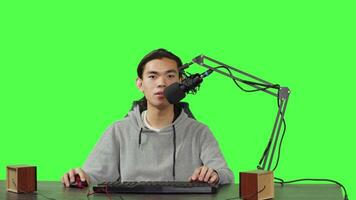 POV of video blogger streaming rpg gameplay over greenscreen in studio, content creator streaming live online competition. Asian streamer playing videogames and broadcasting at desk.