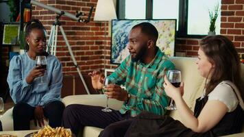 Close up on african american man telling entertaining story to women at apartment party during weekend gathering. Group of friends listening to funny tale from host in living room, zoom in shot video