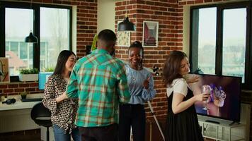 School colleagues celebrating summer break, organizing apartment party, enthusiastically dancing. Cheerful group of friends enjoying time spent together, busting into dance moves video