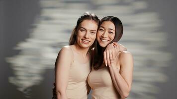 Diverse friends laughing and feeling positive on camera, posing for skincare ad campaign. Happy beautiful women promoting body acceptance and self confidence with beauty routine. photo