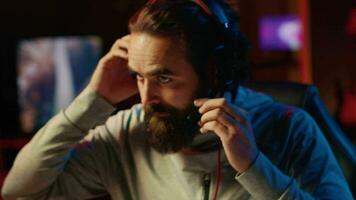 Esports player playing videogames in front of subscribers during livestream, focused on defeating enemies. Close up on cheerful pro gamer streaming game, wearing headphones video