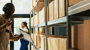 Cheerful man doing funny dance moves in depot space, people laughing at adult dancing. Young warehouse worker acting silly listening to music on headset, working in storage room. photo