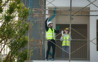 Engineer and architect working on the construction site, double-checking plans and process. photo