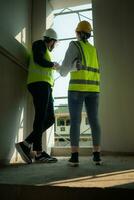 Engineer and architect working on the construction site, double-checking plans and process. photo