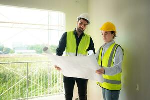 Engineer and architect working on the construction site, double-checking plans and process. photo