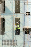 ingeniero y arquitecto trabajando en el construcción sitio, doble revisión planes y proceso. foto