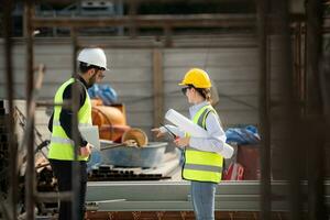Engineer and architect working on the construction site, double-checking plans and process. photo